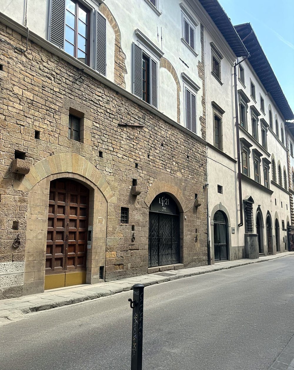 Palazzo Pasqui from Via Bufalini: the medieval stone façade with its arched wooden doorway